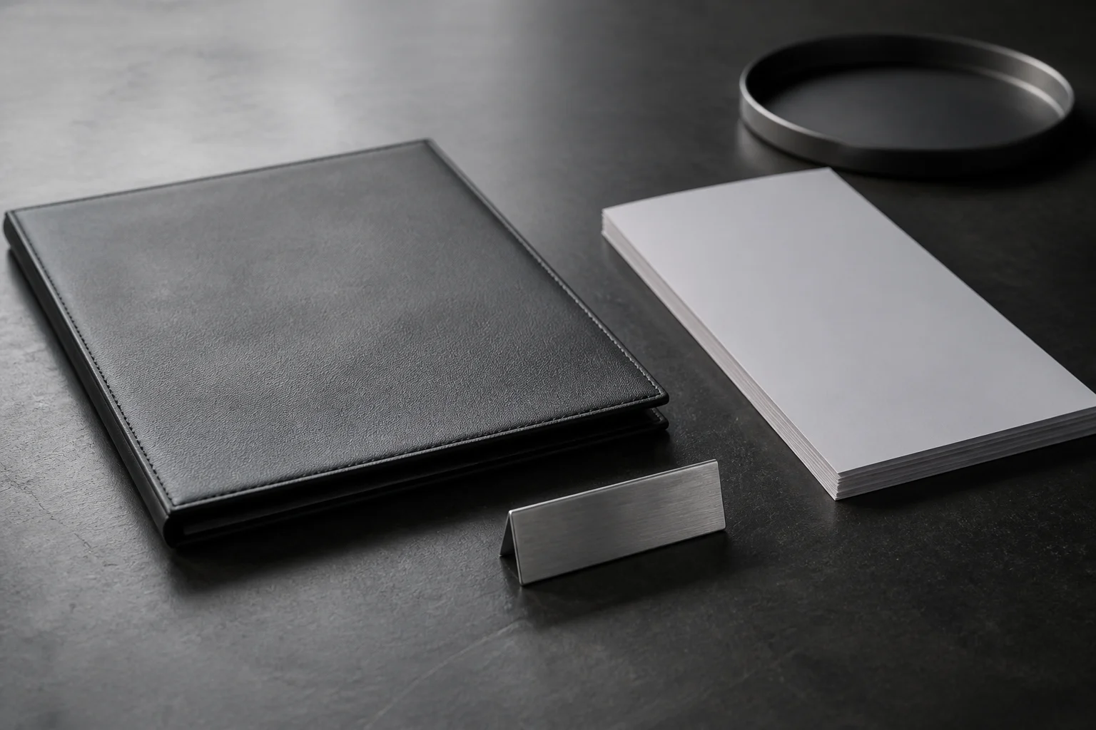 Zinc editorial still life of a closed LP meeting folder, a blank partner nameplate, and a thin board pack, no type on the cover